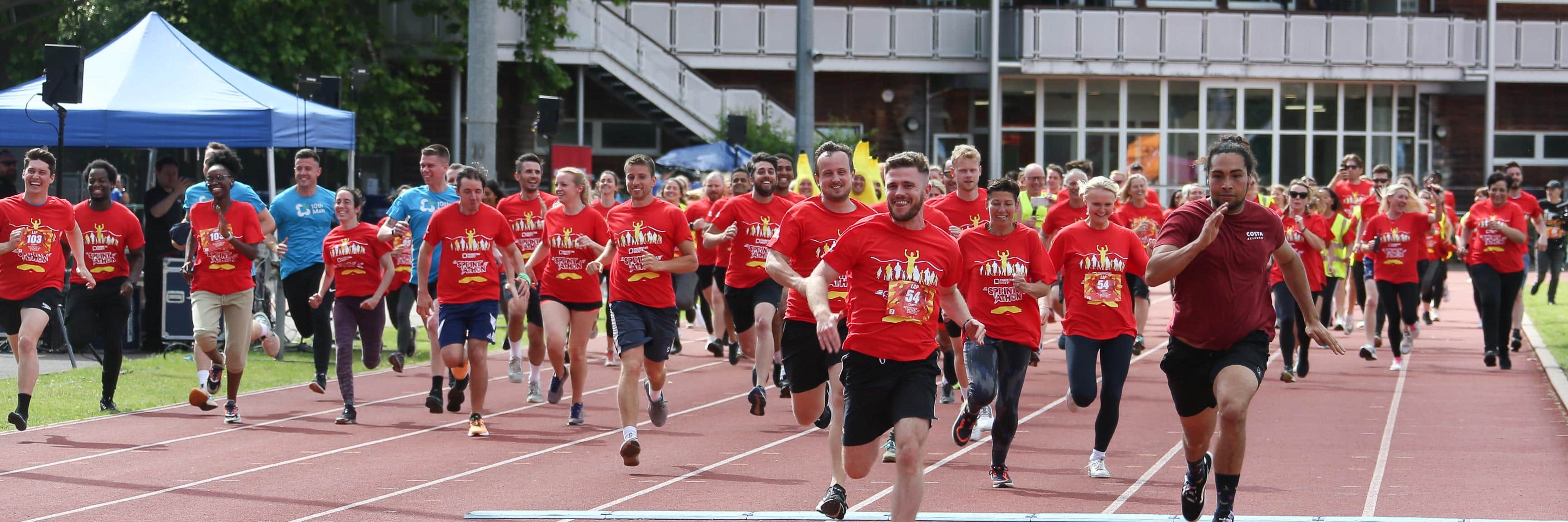 Group of runners in red t-shirts competing in a race.