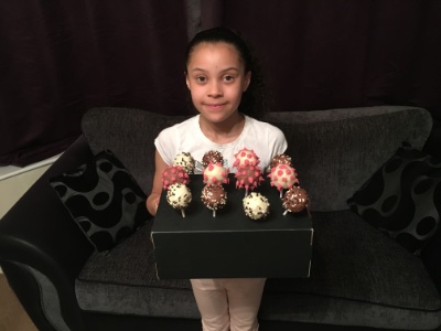 Aliza holding a tray of cake pops