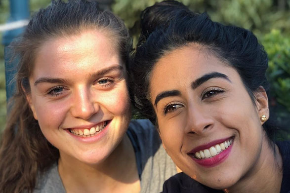 Emily Hayward and her wife Aisha smiling outside in the sun.