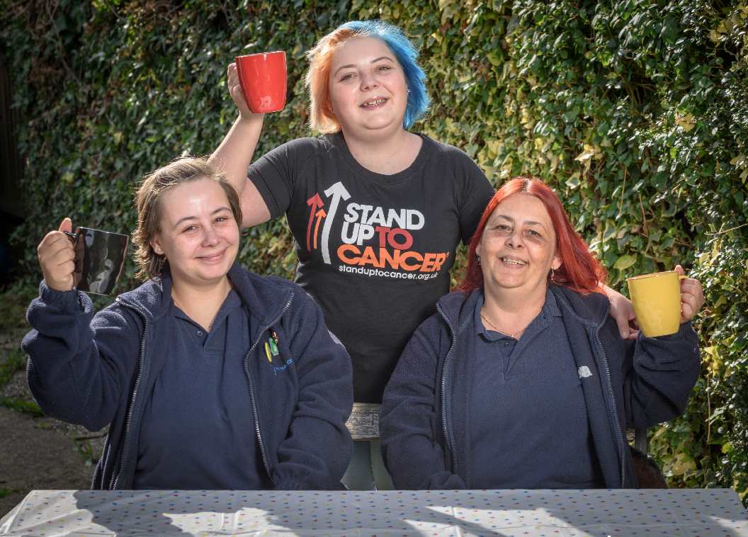 Laura and her family in Stand Up To Cancer t-shirts holding mugs