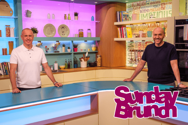 Sunday Brunch Hosts Simon Rimmer and Tim Lovejoy stood in the kitchen on set