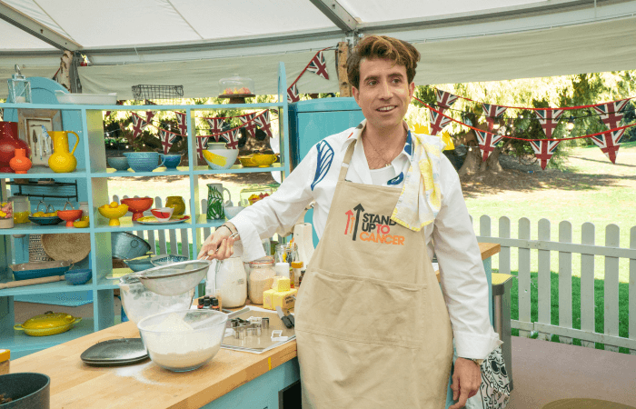 Nick Grimshaw holding a sieve in the Bake Off tent