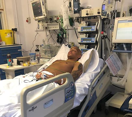 Courtney lying asleep attached to medical equipment.